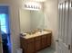 Well-lit bathroom with a spacious countertop, large mirror, and ample cabinet space at 263 Reserve Dr, Davenport, FL 33896