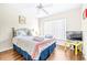 Cozy bedroom with wooden floors, ceiling fan, and a comfortable bed with striped linens at 263 Reserve Dr, Davenport, FL 33896