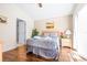 Cozy bedroom featuring wood floors, neutral walls, artwork, and a queen-size bed with gray patterned comforter at 263 Reserve Dr, Davenport, FL 33896