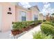 Close up of the front of the pink home featuring white shutters and lush landscaping at 263 Reserve Dr, Davenport, FL 33896