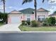 Charming pink single-story home featuring a well-manicured lawn and tropical landscaping at 263 Reserve Dr, Davenport, FL 33896