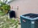 Exterior view of the home's air conditioning units surrounded by grass and trees at 263 Reserve Dr, Davenport, FL 33896