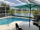 Screened-in lanai with a swimming pool and views of the water and neighboring homes at 263 Reserve Dr, Davenport, FL 33896