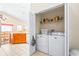 Convenient laundry room located off of the kitchen with a washer, dryer, and storage shelf at 263 Reserve Dr, Davenport, FL 33896