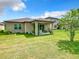 A serene backyard featuring a covered patio and lush green lawn at 278 Alford Dr, Davenport, FL 33896