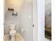 Clean powder room with a modern toilet, floating shelves, and a doorway to a shower at 278 Alford Dr, Davenport, FL 33896