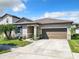 Inviting single-Gathering house with a landscaped front yard, neutral exterior paint, and an attached two-car garage at 278 Alford Dr, Davenport, FL 33896