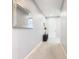 Clean, bright hallway with neutral paint, carpet, and tiled entryway, accented by decorative mirror and table at 278 Alford Dr, Davenport, FL 33896