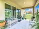 Covered patio with outdoor seating, plants, and a view of the lush backyard at 278 Alford Dr, Davenport, FL 33896
