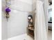 Bright shower with white tiled walls, a shower caddy, and wooden bench at 278 Alford Dr, Davenport, FL 33896