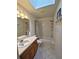Well-lit bathroom with tile floors, a skylight, a vanity with wooden cabinets, and a shower-tub combo at 2909 Pine Tree Dr, Edgewater, FL 32141