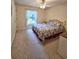 Bright bedroom with neutral carpet, a large window, and a comfortable bed with colorful bedding at 2909 Pine Tree Dr, Edgewater, FL 32141