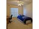 Cozy bedroom with neutral carpet, ceiling fan, and ample natural light from the large window at 2909 Pine Tree Dr, Edgewater, FL 32141