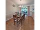 Bright dining room with modern chandelier and large glass table near glass doors that lead to an outside space at 2909 Pine Tree Dr, Edgewater, FL 32141
