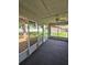 Covered patio with screens, fan, and concrete floor, offering a relaxing outdoor living space at 2909 Pine Tree Dr, Edgewater, FL 32141