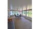 Glass enclosed sunroom with table, chairs, and fan, overlooking the backyard at 2909 Pine Tree Dr, Edgewater, FL 32141