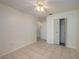Bedroom with neutral walls, tile flooring, ceiling fan, and closet with louvered doors at 299 Winter Ridge Blvd # 299, Winter Haven, FL 33881