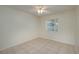 Minimalist bedroom with neutral walls, tile flooring, and a bright window at 299 Winter Ridge Blvd # 299, Winter Haven, FL 33881