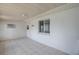 A covered patio with tile flooring, a window, and a wall-mounted air conditioning unit at 299 Winter Ridge Blvd # 299, Winter Haven, FL 33881