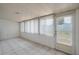 A sunroom with tile flooring and multiple windows with vertical blinds for natural light at 299 Winter Ridge Blvd # 299, Winter Haven, FL 33881