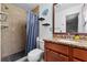 Bathroom features stone floors, updated vanity, shower with blue curtains and shelving at 320 Boger S Blvd, Lakeland, FL 33803