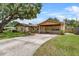 Charming single-story home featuring a covered carport, long driveway and well-manicured landscaping at 320 Boger S Blvd, Lakeland, FL 33803