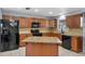 Well-lit kitchen featuring wooden cabinets, black appliances, and a center island at 320 Boger S Blvd, Lakeland, FL 33803