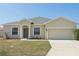 Charming single-story home with a neutral-colored exterior, a well-manicured lawn, and an attached two-car garage at 327 Cloverdale Rd, Winter Haven, FL 33884
