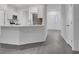 Open-concept kitchen with large island, white cabinets, stainless appliances, and gray flooring at 327 Cloverdale Rd, Winter Haven, FL 33884