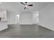 Open floor plan featuring durable grey flooring, a ceiling fan, and a view of the modern kitchen area at 327 Cloverdale Rd, Winter Haven, FL 33884
