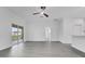 Open layout with light-colored flooring, sliding glass doors leading to the outdoor space, and a ceiling fan at 327 Cloverdale Rd, Winter Haven, FL 33884