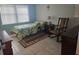 Comfortable bedroom with a twin bed, rocking chair, and ample natural light, creating a relaxing atmosphere at 333 Lake Howard Nw Dr # 312D, Winter Haven, FL 33880