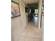 Inviting hallway with neutral tile flooring, art decorations and natural light streaming from the entrance at 333 Lake Howard Nw Dr # 312D, Winter Haven, FL 33880