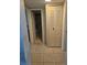 Hallway view showcasing a glimpse of the bathroom and a closet, complemented by neutral-toned tile flooring at 333 Lake Howard Nw Dr # 312D, Winter Haven, FL 33880