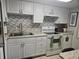 Bright kitchen featuring white cabinets, sleek countertops, and modern appliances at 333 Lake Howard Nw Dr # 312D, Winter Haven, FL 33880