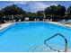 Sparkling community pool with lounge chairs, umbrellas, and clear blue water, perfect for relaxation at 333 Lake Howard Nw Dr # 312D, Winter Haven, FL 33880
