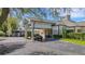 Inviting clubhouse entrance featuring an overhead canopy, lush foliage, and convenient parking at 351 Enclave Dr # 94, Lakeland, FL 33803