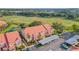Aerial view of condo building showcasing lush landscaping, red tile roof, and assigned covered parking at 351 Enclave Dr # 94, Lakeland, FL 33803