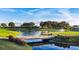 Peaceful pond view with a small bridge, surrounding trees, and a water fountain in the background at 351 Enclave Dr # 94, Lakeland, FL 33803