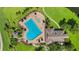 Aerial view of a kidney-shaped swimming pool with lounge chairs and palm trees surrounded by lush landscaping at 351 Enclave Dr # 94, Lakeland, FL 33803