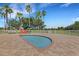 pool with a splash pad and lounge chairs surrounded by palm trees in community at 351 Enclave Dr # 94, Lakeland, FL 33803