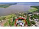 Aerial view of the home with a pool near the lake surrounded by lush greenery at 3705 Pine Cir, Lake Wales, FL 33898