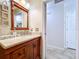 Elegant bathroom featuring a wood vanity with granite countertop and a decorative mirror at 3705 Pine Cir, Lake Wales, FL 33898