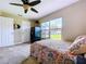 Bright bedroom featuring a bed with colorful patterned bedding, a large window, and a Field and Stream safe at 3705 Pine Cir, Lake Wales, FL 33898