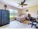 Cozy bedroom with patterned bedding, large window overlooking a lush lawn and a secure Field and Stream safe at 3705 Pine Cir, Lake Wales, FL 33898