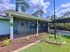 Inviting front porch area with a screened enclosure, hanging plants, and manicured landscaping at 3705 Pine Cir, Lake Wales, FL 33898