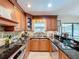 A stylish kitchen featuring dark granite countertops, wood cabinets, stainless steel appliances and a window over the sink at 3705 Pine Cir, Lake Wales, FL 33898