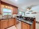 A beautiful kitchen with dark granite countertops and tiled backsplash and a large bright window at 3705 Pine Cir, Lake Wales, FL 33898