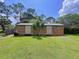 Expansive backyard with lush lawn and versatile outbuilding featuring dual entrances for various uses at 3705 Pine Cir, Lake Wales, FL 33898