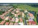 Community aerial showcasing beautiful homes, mature trees, pond, and green spaces at 380 Niblick Cir, Winter Haven, FL 33881